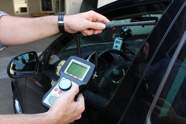 Ultrasonic tightness testing at a car with ultrasonic testing device and sensor